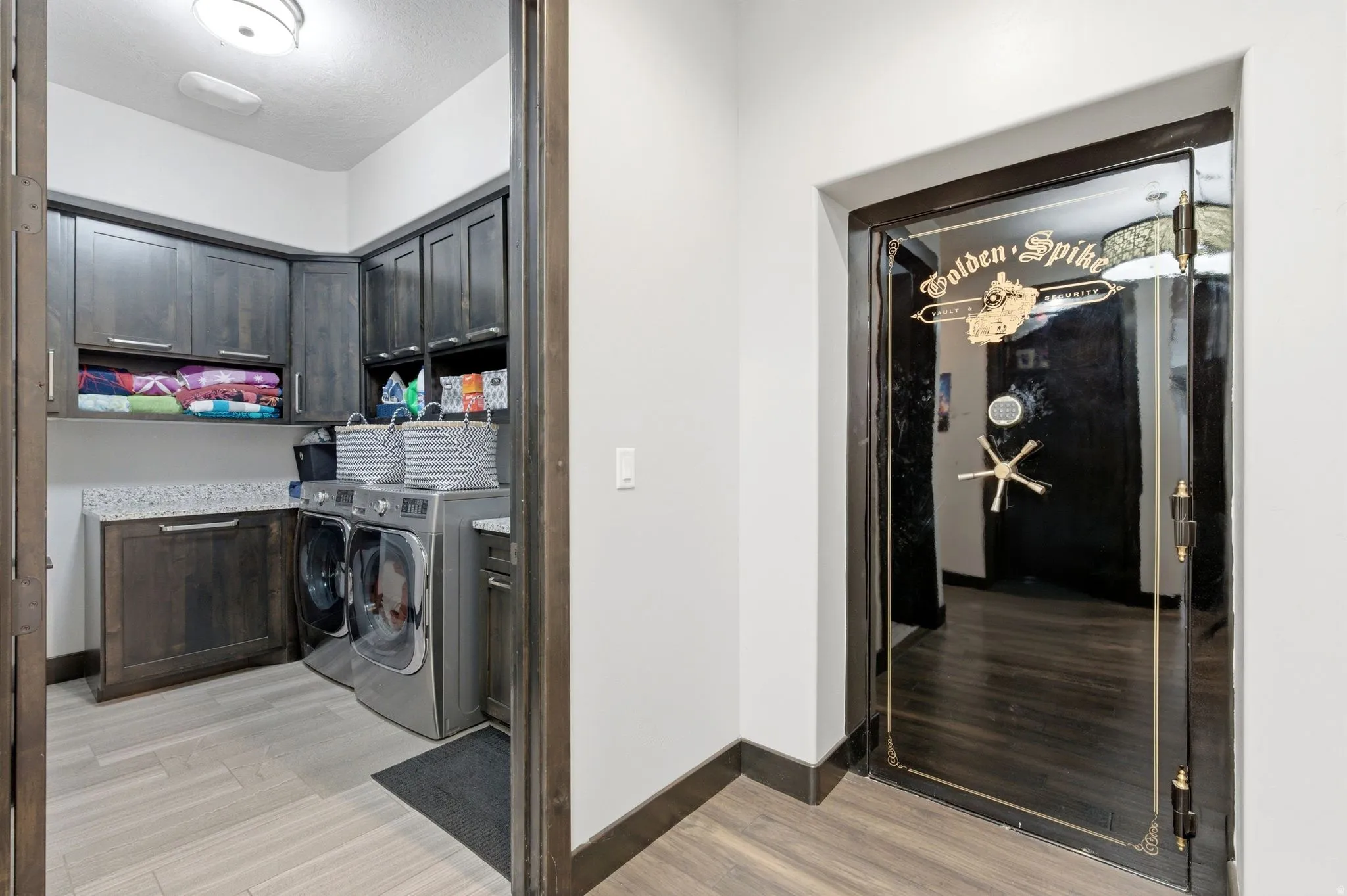 Dedicated laundry area with stone-look countertops and extensive dark wood-finish cabinetry