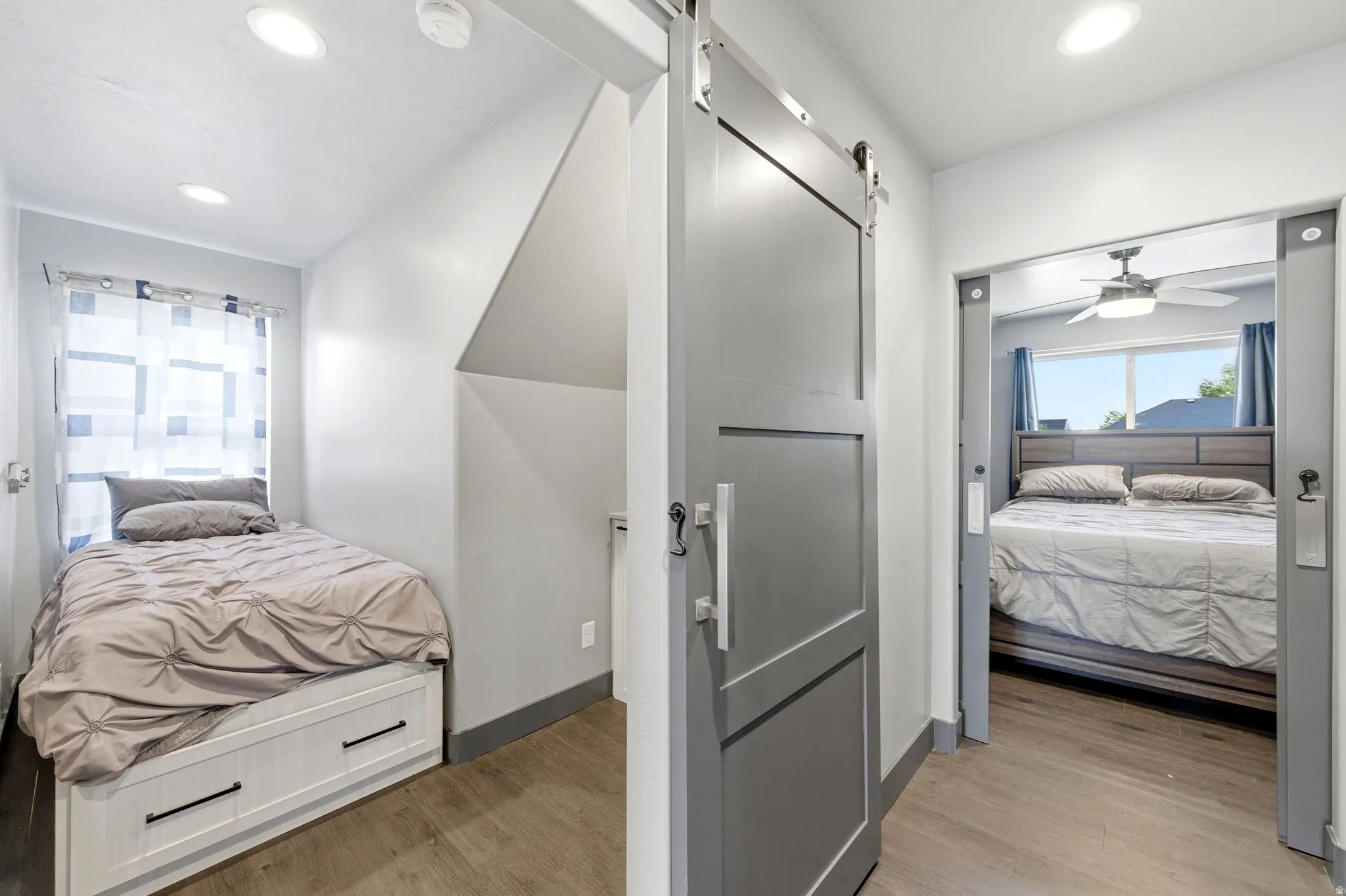Interior hallway featuring wood-finish flooring, recessed lighting, and a modern gray barn door