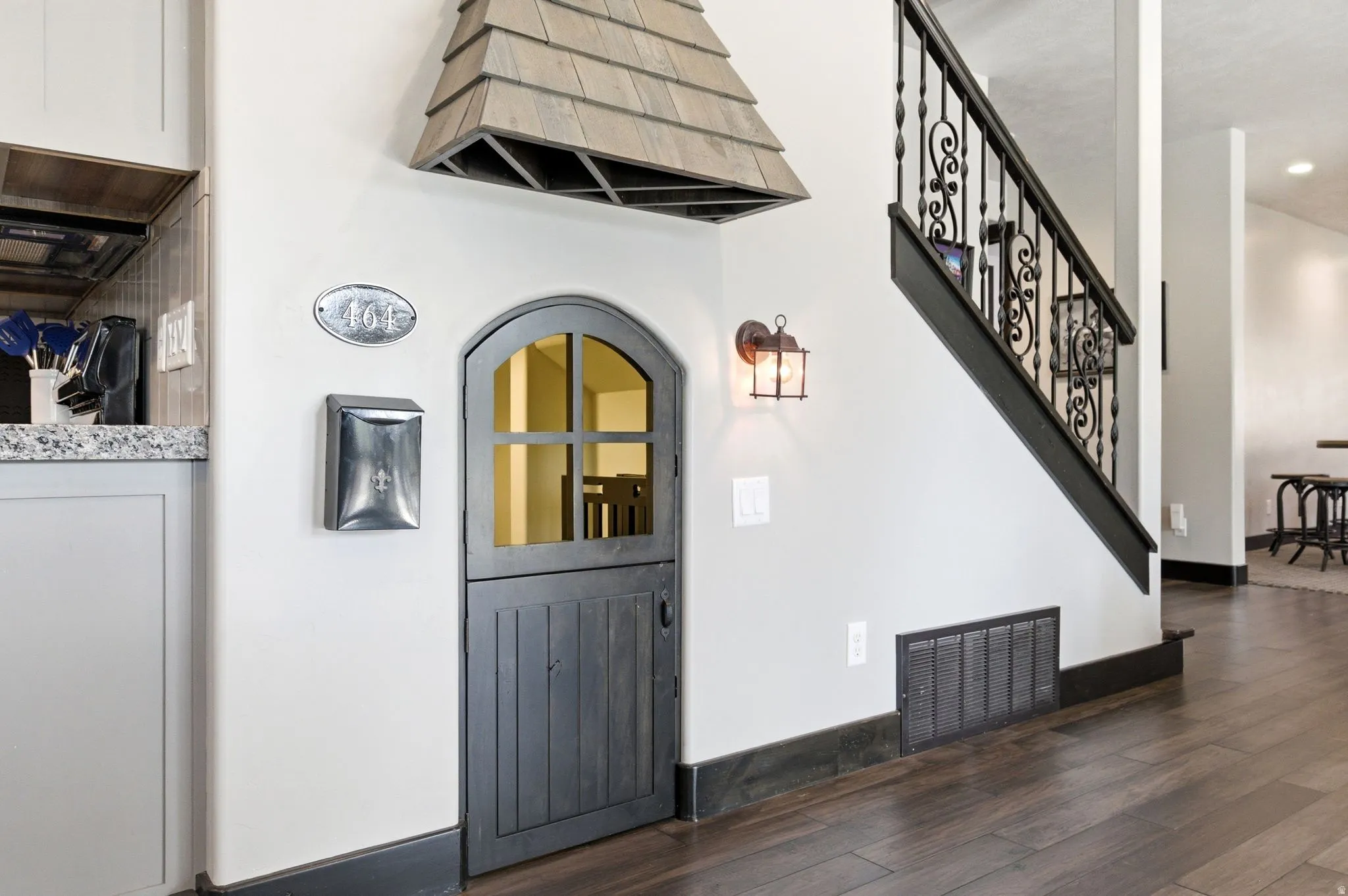 Custom arched Dutch door with upper window pane detail, complemented by a decorative shingled overhang