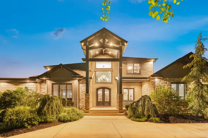 Grand entry with a prominent covered porch, double-door entry, and expansive windows