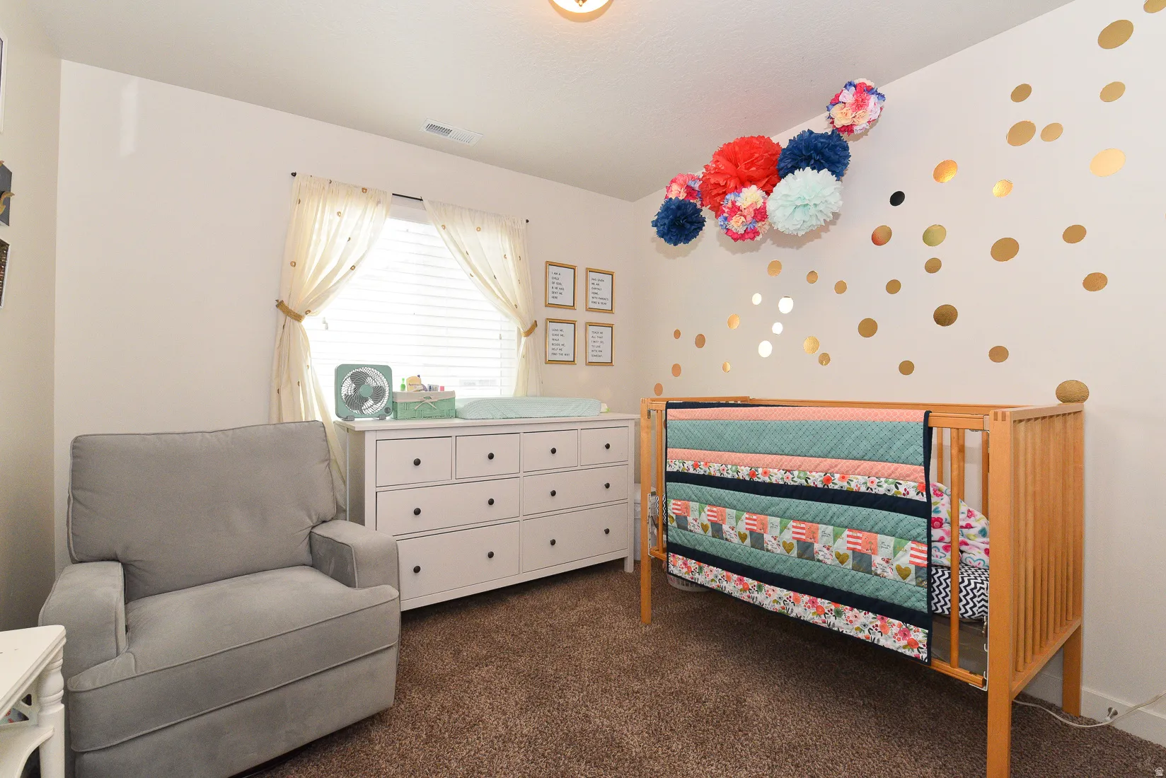 Carpeted room featuring a window with blinds, a built-in ceiling light fixture, a white dresser with dark hardware, and light-toned walls