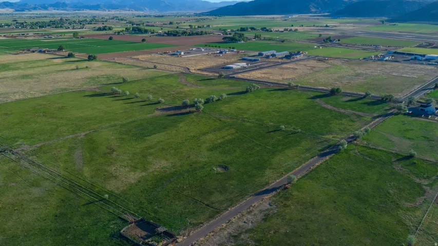 Expansive agricultural land featuring a verdant field and distant mountain range