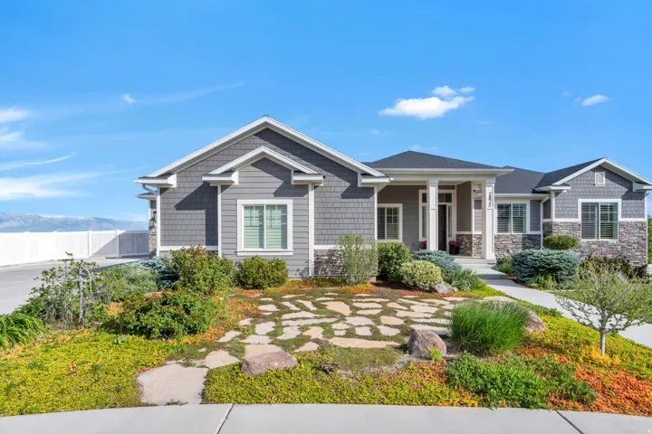 Ranch-style residence featuring a combination of gray siding, shake siding, and stone veneer accents