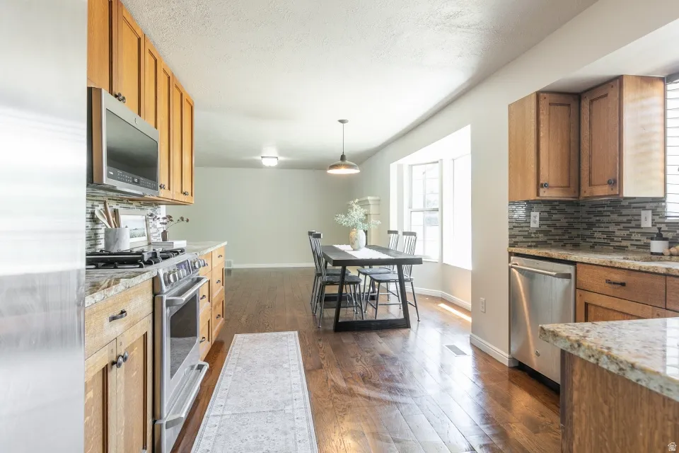 Kitchen featuring wood cabinetry, stainless steel appliances, and granite countertops