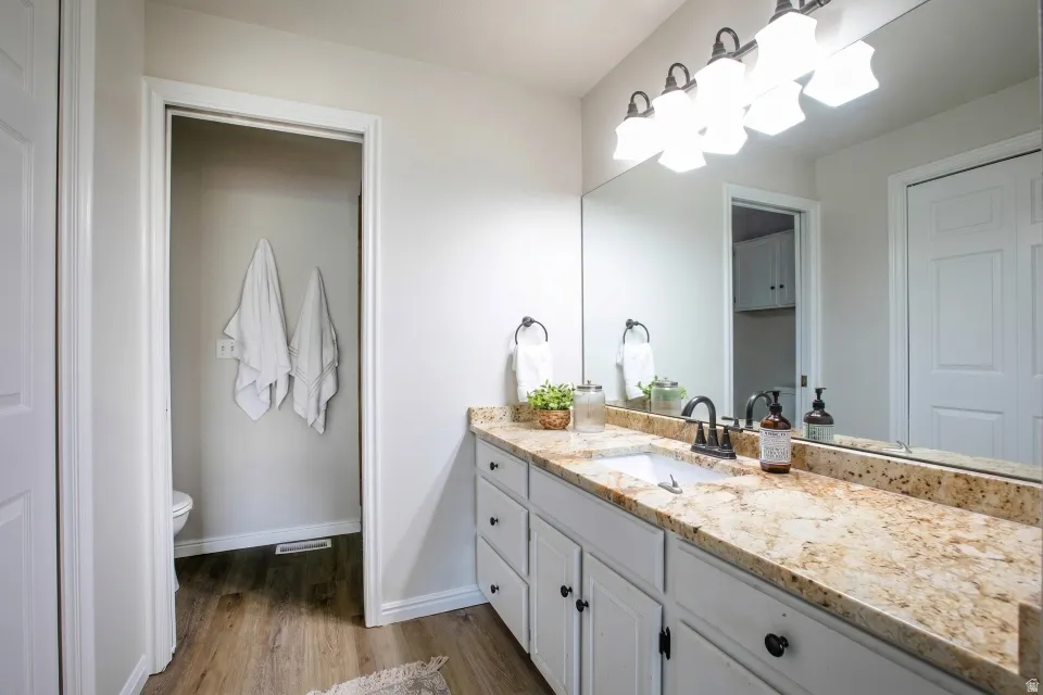 Bathroom featuring a long vanity with a light-toned countertop, undermount sink, and matte black faucet