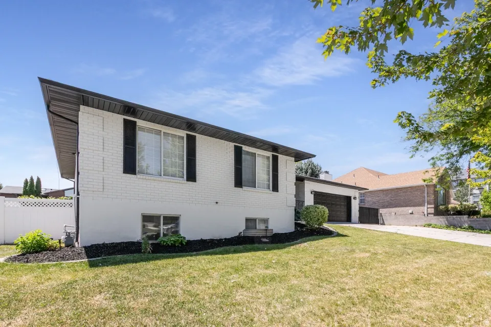 White brick exterior with black shutters and a black roofline
