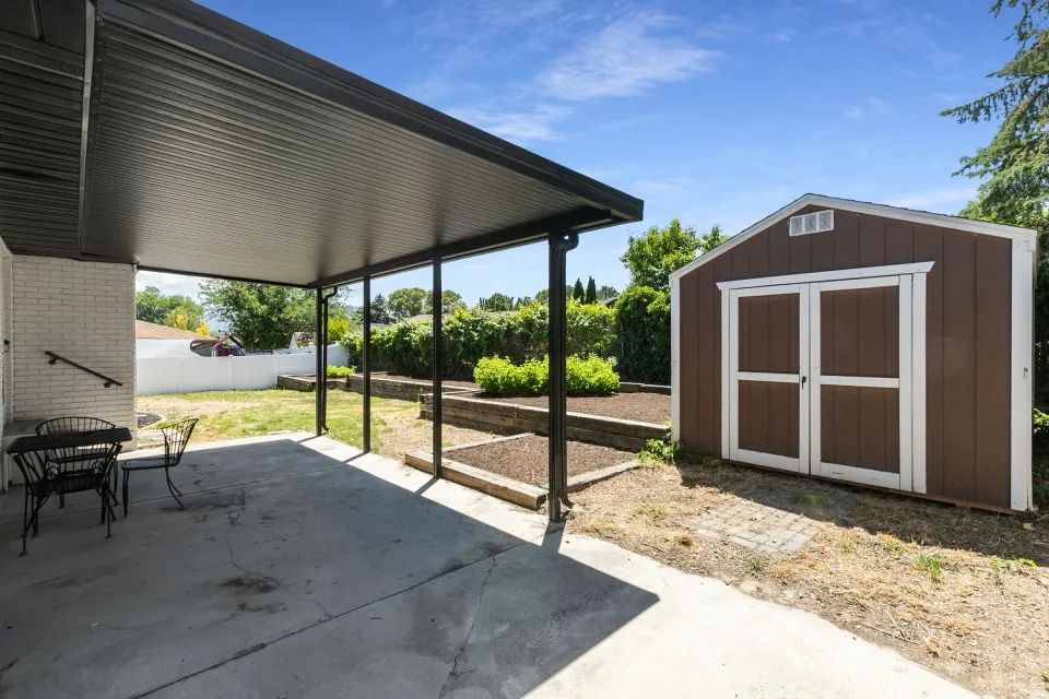 Covered concrete patio with a permanent shed