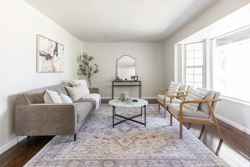 Spacious room featuring wood-finish flooring, a large bay window, and light-toned walls