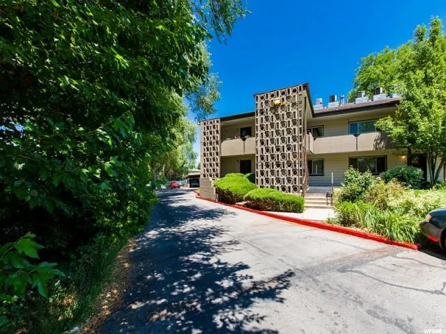 Two-story exterior featuring a decorative screen facade, stucco siding, and multiple balconies