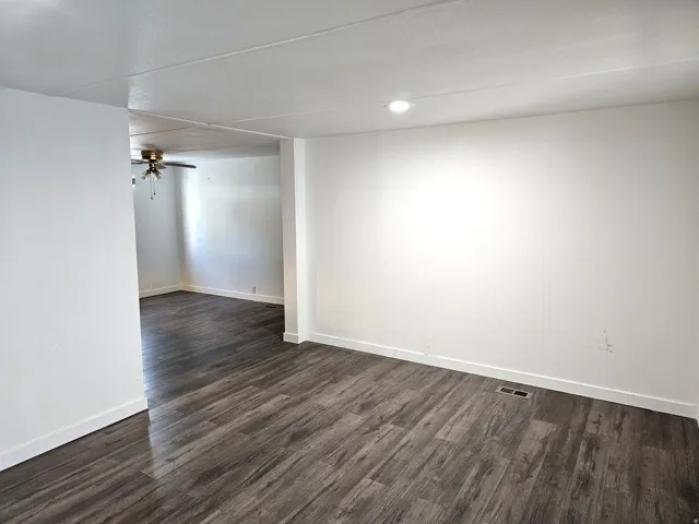 Spacious interior featuring wood-finish flooring, white baseboards, and a recessed ceiling light