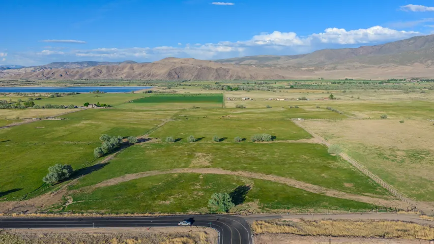 Expansive green fields with a visible road frontage