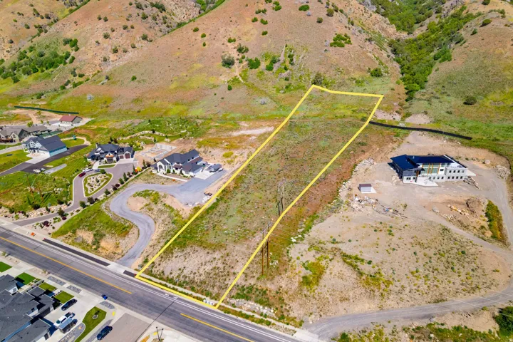 Expansive lot with a mountain backdrop, featuring direct road frontage and visible utility poles