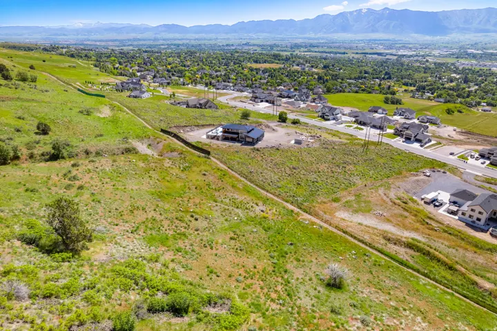Expansive land parcel featuring existing infrastructure and mountain scenery
