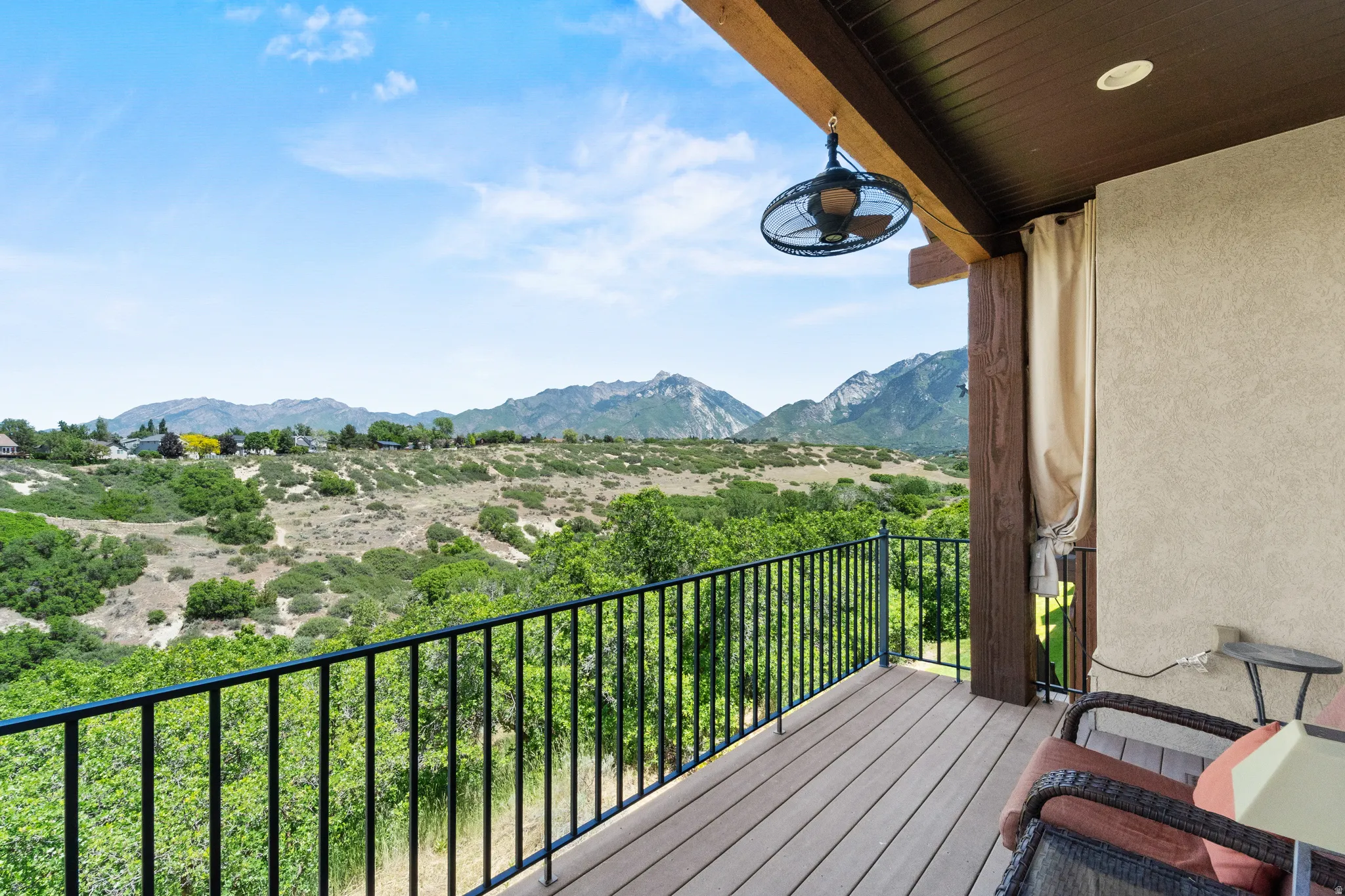 Outdoor deck featuring composite decking and a wrought iron railing