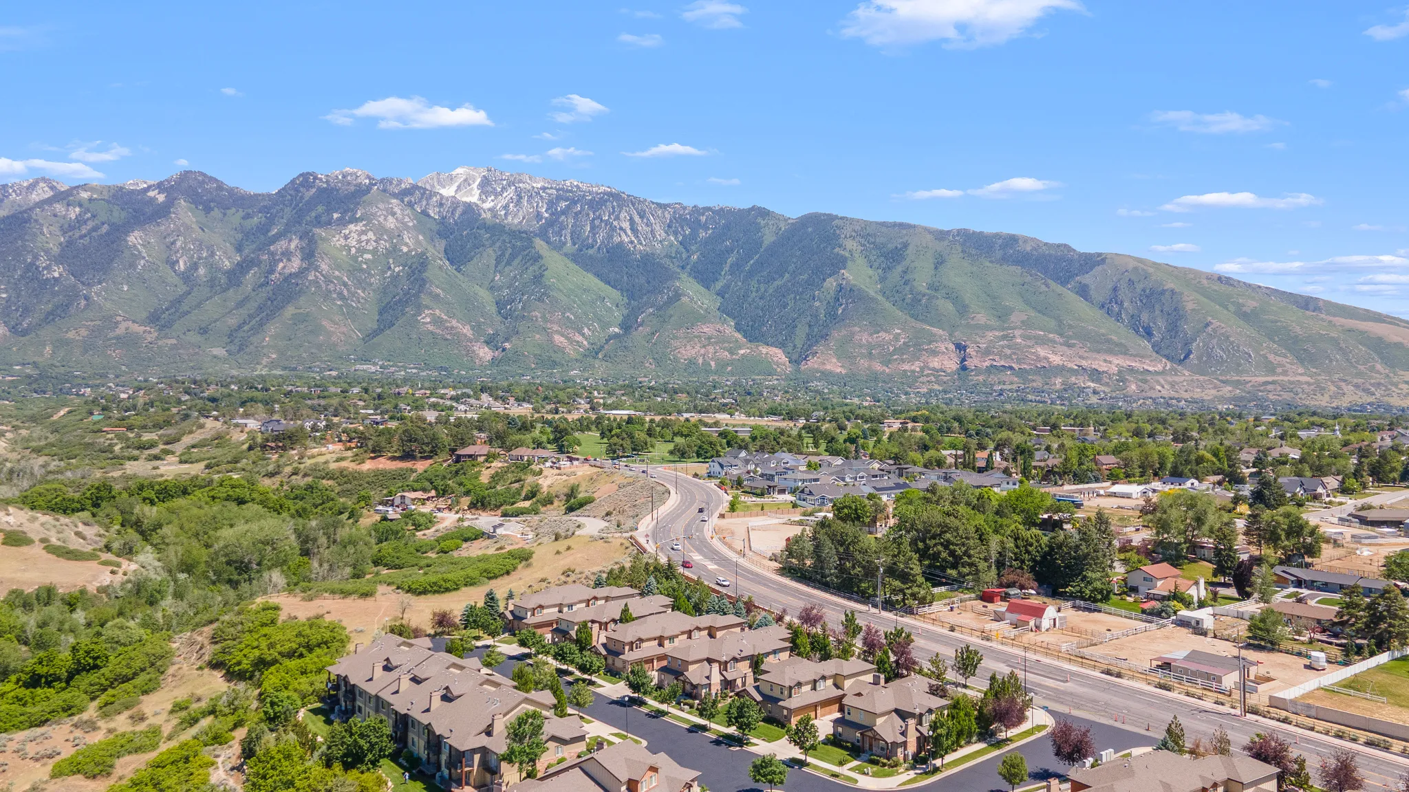 Aerial perspective showcasing a residential development with multi-story buildings, dark roofs, and light-colored siding