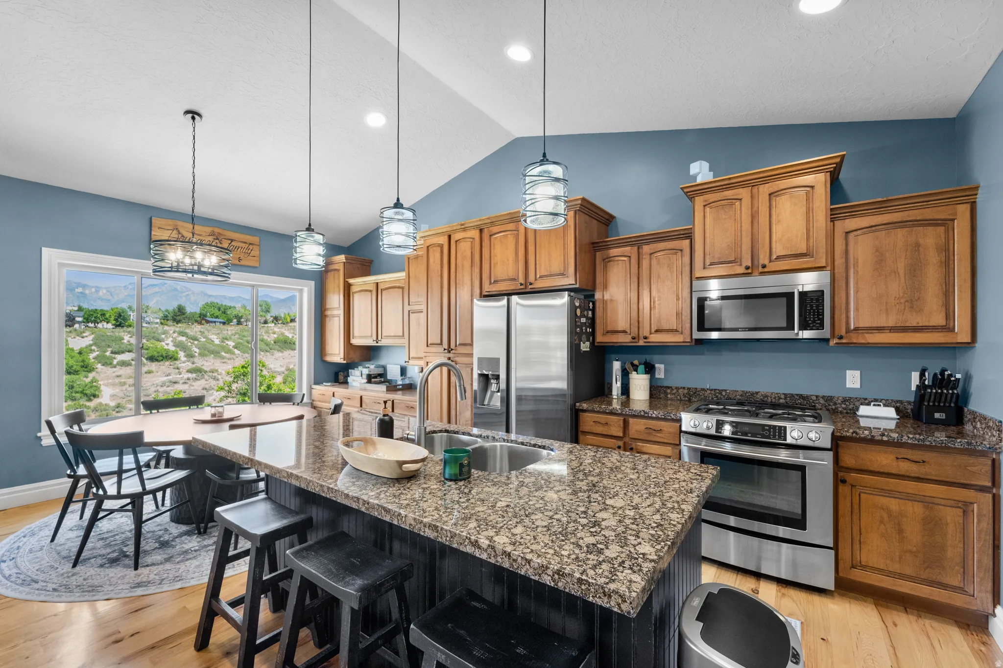 Kitchen featuring wood-finish flooring, vaulted ceilings, and wood cabinetry