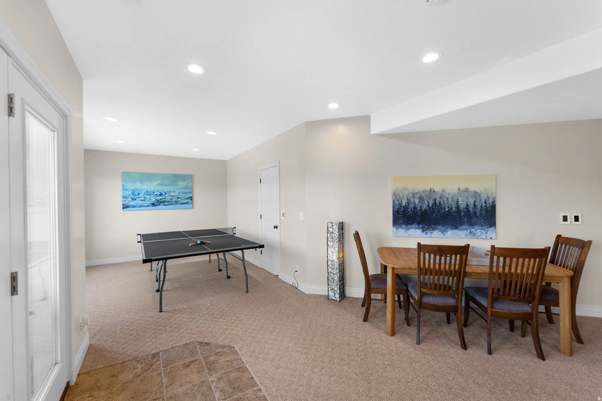 Spacious recreation room featuring recessed lighting, light-toned carpeting, and a glass-paneled door