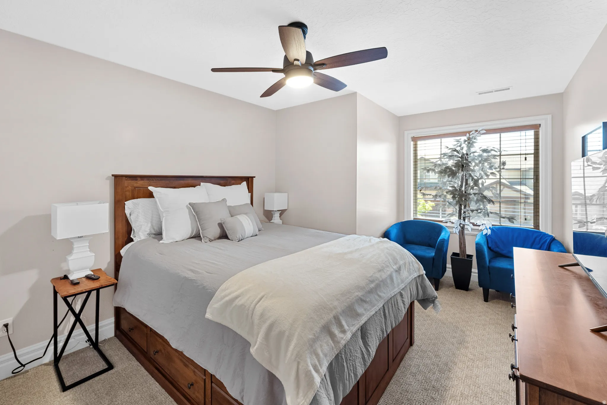 Spacious bedroom featuring neutral wall tones and light-colored carpeting