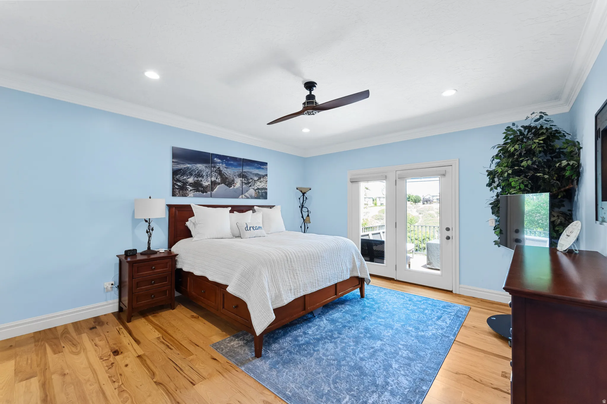 Room featuring light wood-finish flooring, white crown molding, recessed lighting, and a dark wood ceiling fan