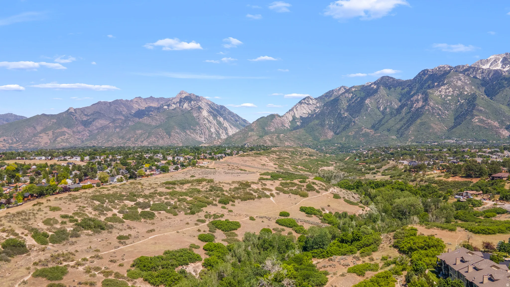 Expansive landscape featuring mountains, a valley, and scattered residential areas