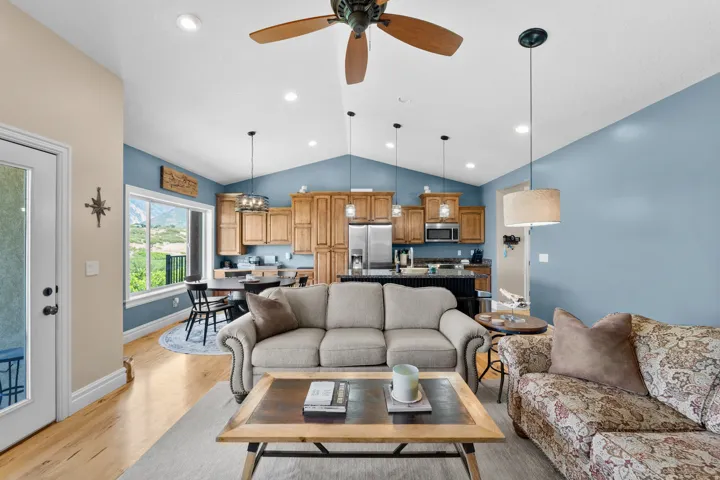 Open-concept living space with vaulted ceilings, recessed lighting, and wood-finish flooring