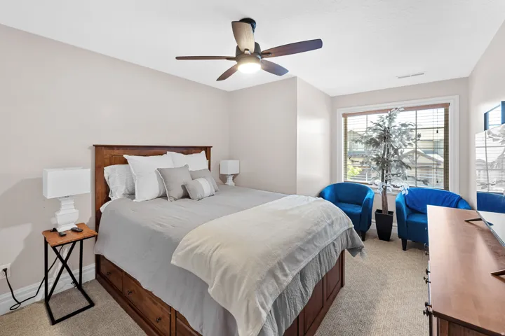 Spacious bedroom featuring neutral wall tones and light-colored carpeting