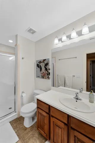 Bathroom featuring a single vanity with wood-finish cabinetry, a white countertop, and an integrated white sink