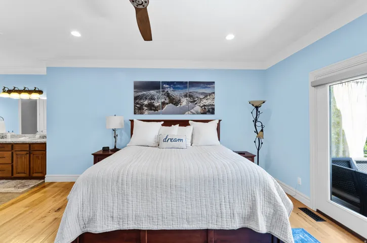 Light-filled room featuring wood-finish flooring, recessed lighting, and a ceiling fan