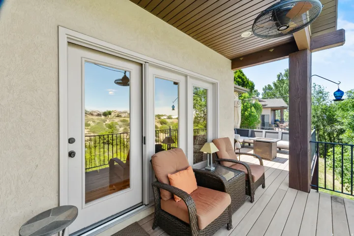 Covered outdoor patio featuring a wood-finish ceiling, ceiling fan, and composite decking