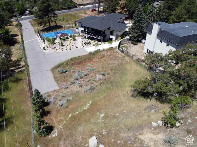 Expansive land parcel featuring natural landscaping with scattered trees and shrubs