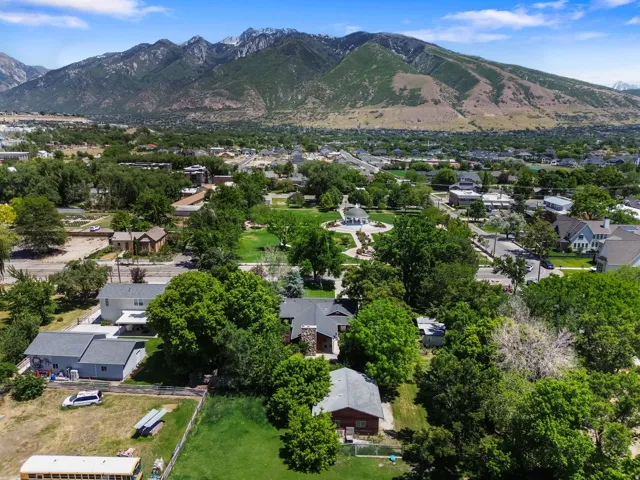 Townscape featuring residential properties, mature trees, and a mountain backdrop