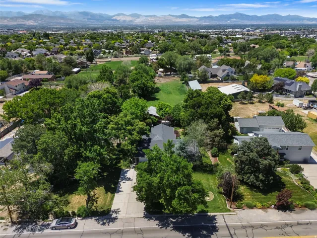 Aerial perspective showcasing a residential property with extensive mature landscaping, including numerous trees and green space