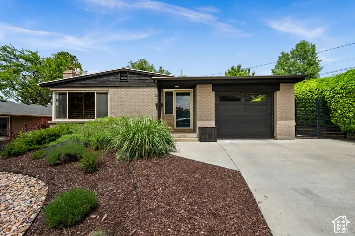 Mid-century modern exterior featuring brick and dark wood siding