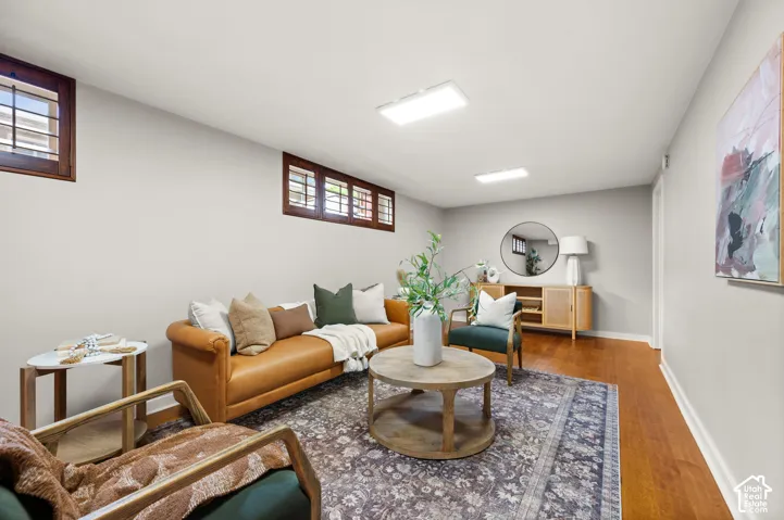 Living area featuring wood-finish flooring, light grey walls, and recessed lighting