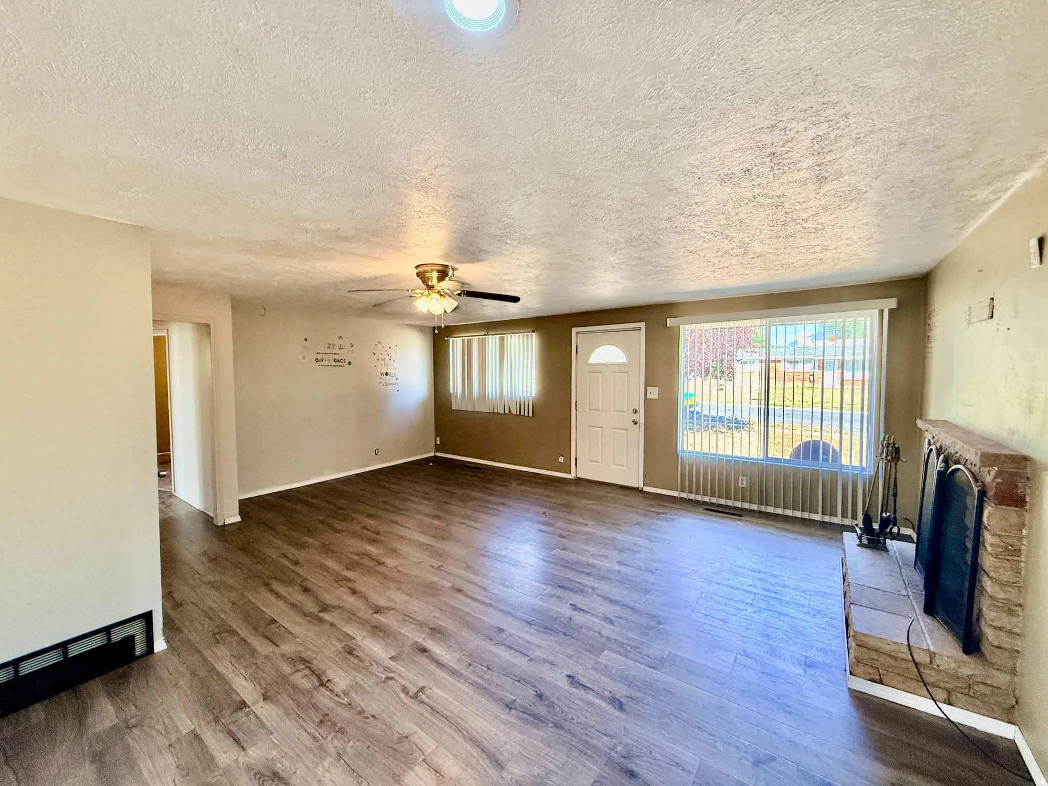 Spacious room featuring wood-finish flooring, a ceiling fan, and recessed lighting