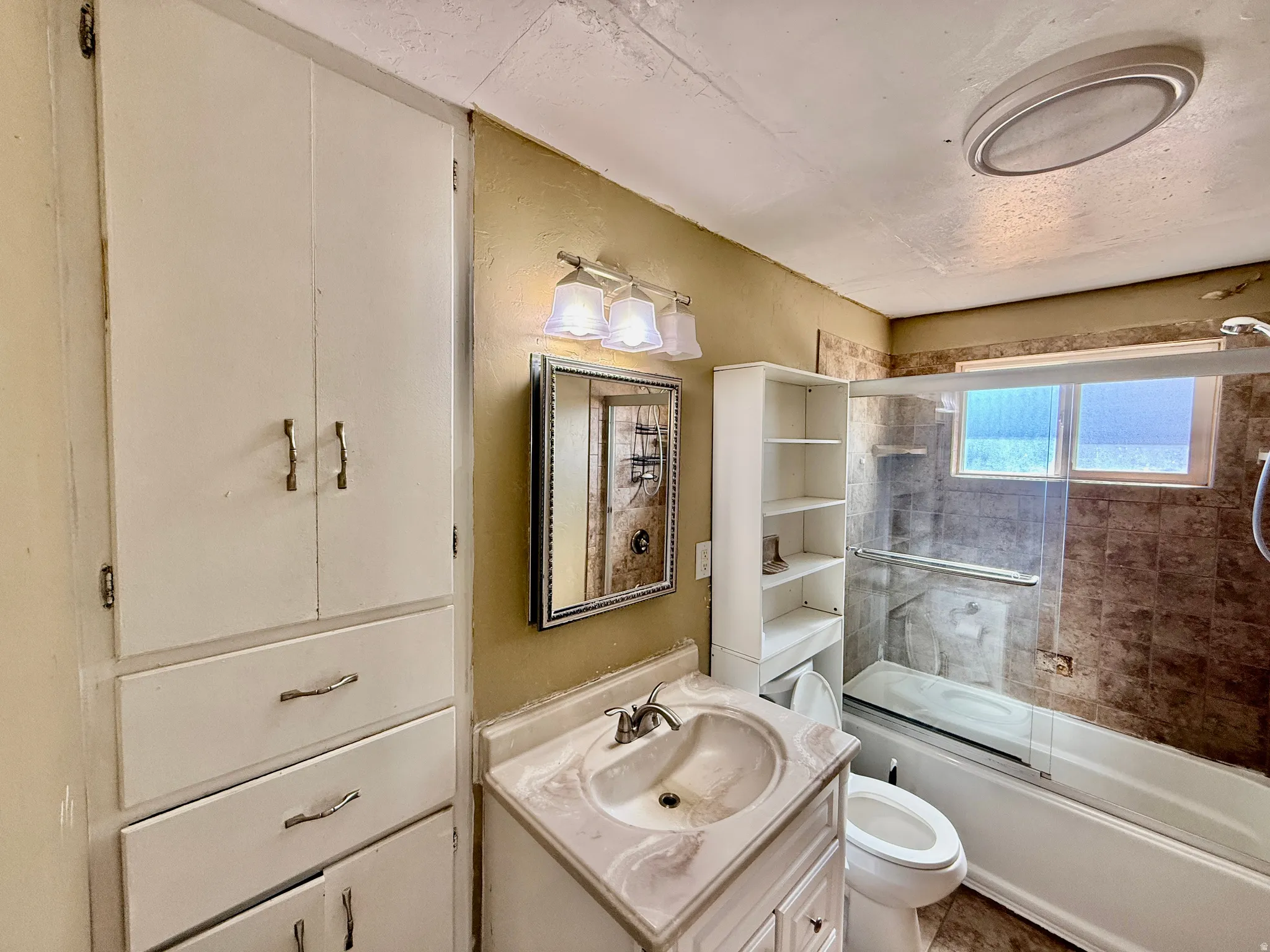 Bathroom featuring a full vanity with an integrated sink, mirrored medicine cabinet, and overhead lighting