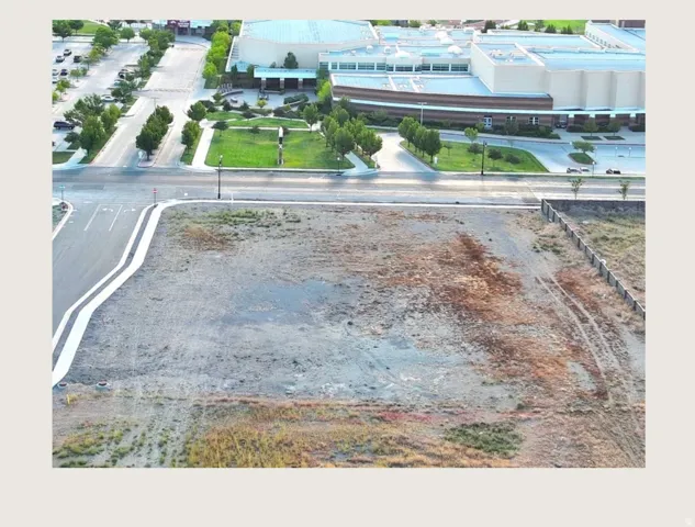 Expansive undeveloped parcel featuring established perimeter fencing and direct street frontage with curb and gutter