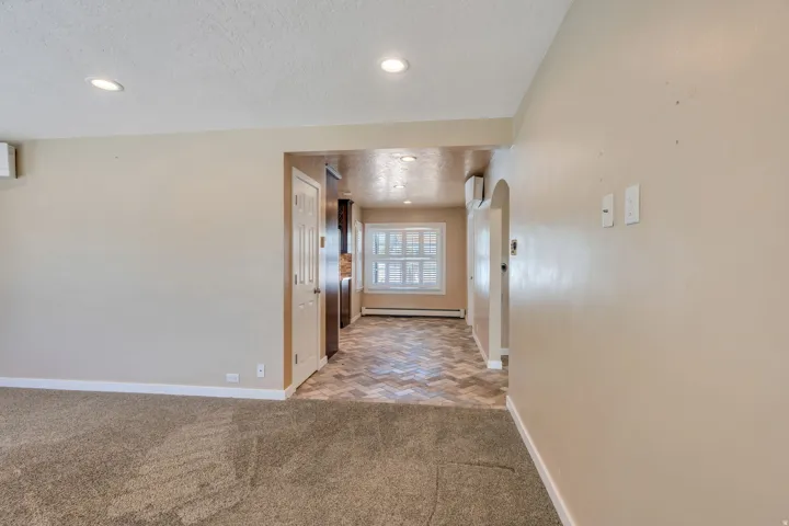 Neutral-toned walls with recessed lighting and crown molding