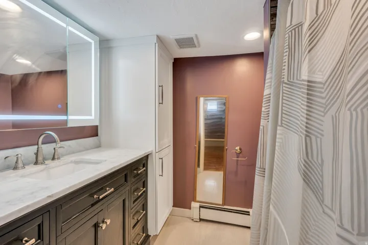 Bathroom featuring a vanity with dark wood-finish cabinetry, a white countertop, and a built-in sink