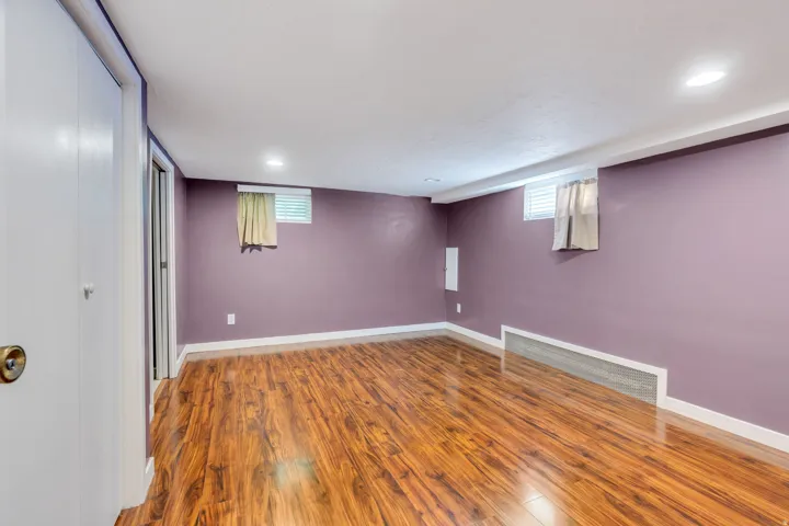 Interior room featuring wood-finish flooring, recessed lighting, and pastel purple walls