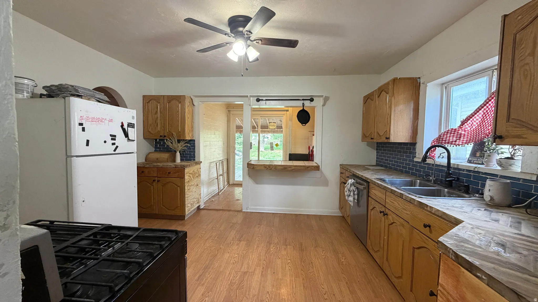 Kitchen featuring wood-finish flooring, natural wood cabinetry, and an undermount double-basin sink