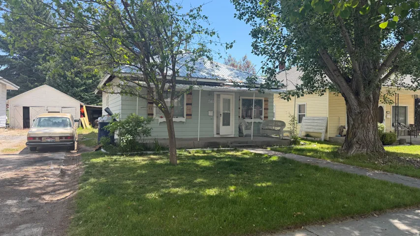 Light green siding exterior with a covered front porch and a metal roof