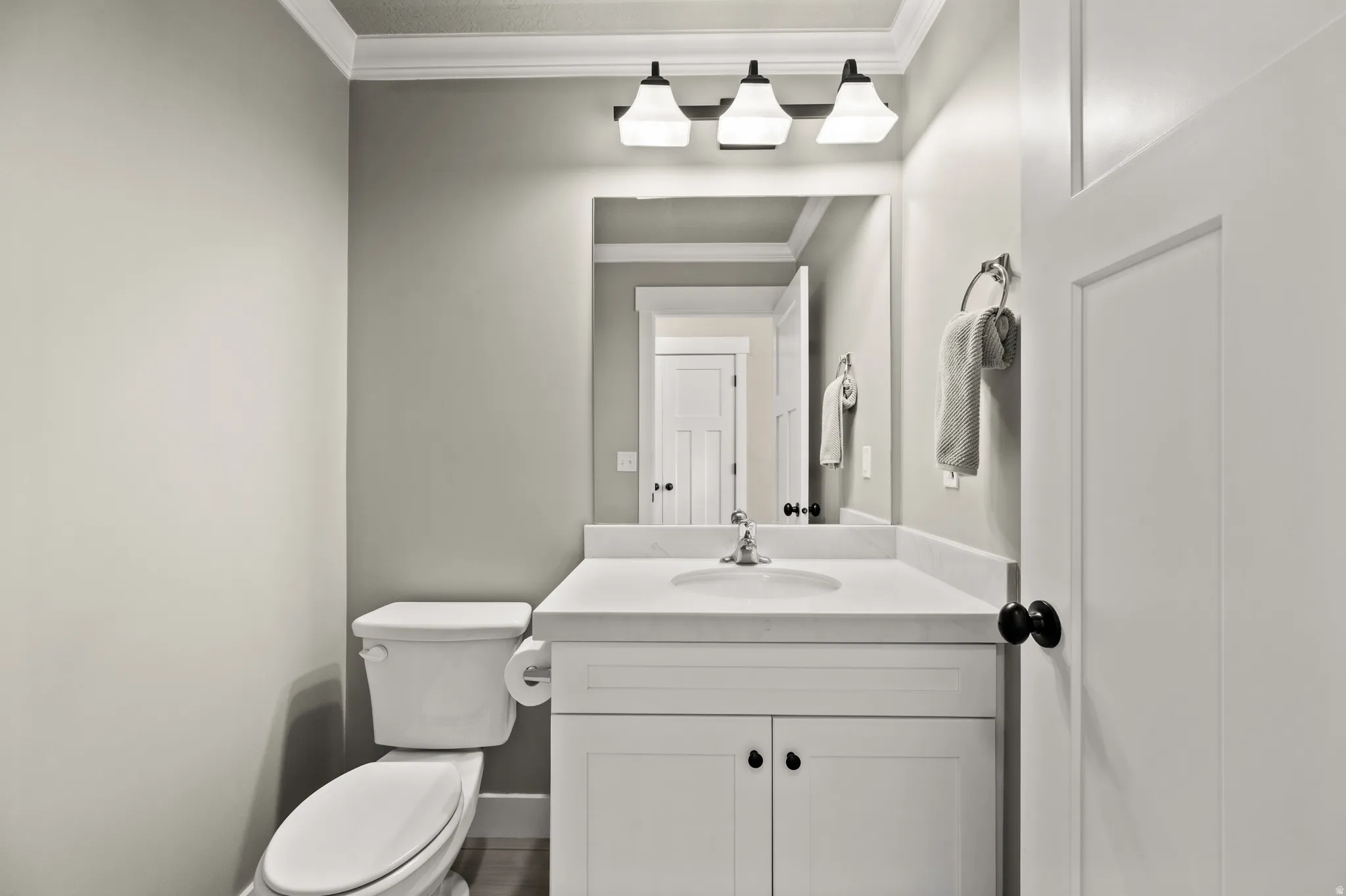 Bathroom featuring a white vanity with a white countertop, an undermount sink, a chrome faucet, and a large mirror