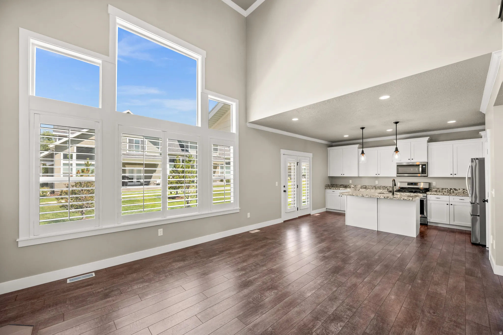 Open-concept living area featuring a vaulted ceiling and dark wood-finish flooring
