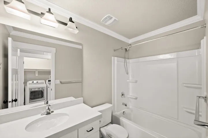 Bathroom featuring a white vanity with an undermount sink, a white countertop, and a chrome faucet