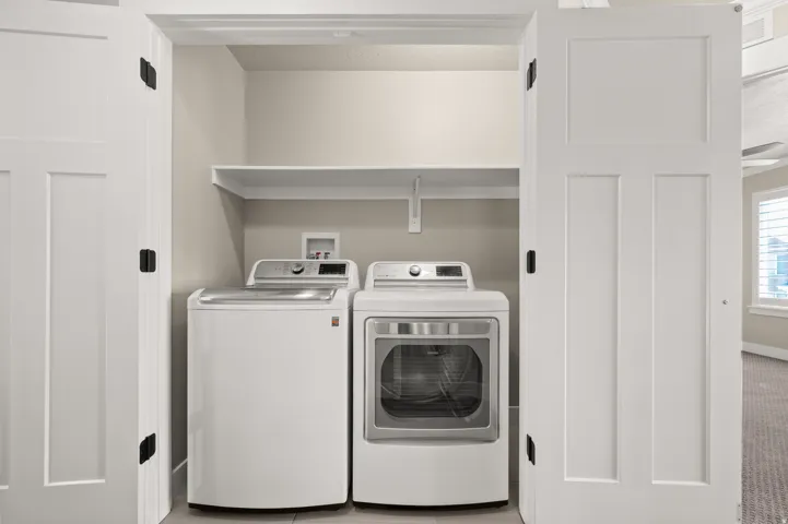 Utility closet featuring a built-in shelf, neutral wall tones, and panel doors with dark hardware