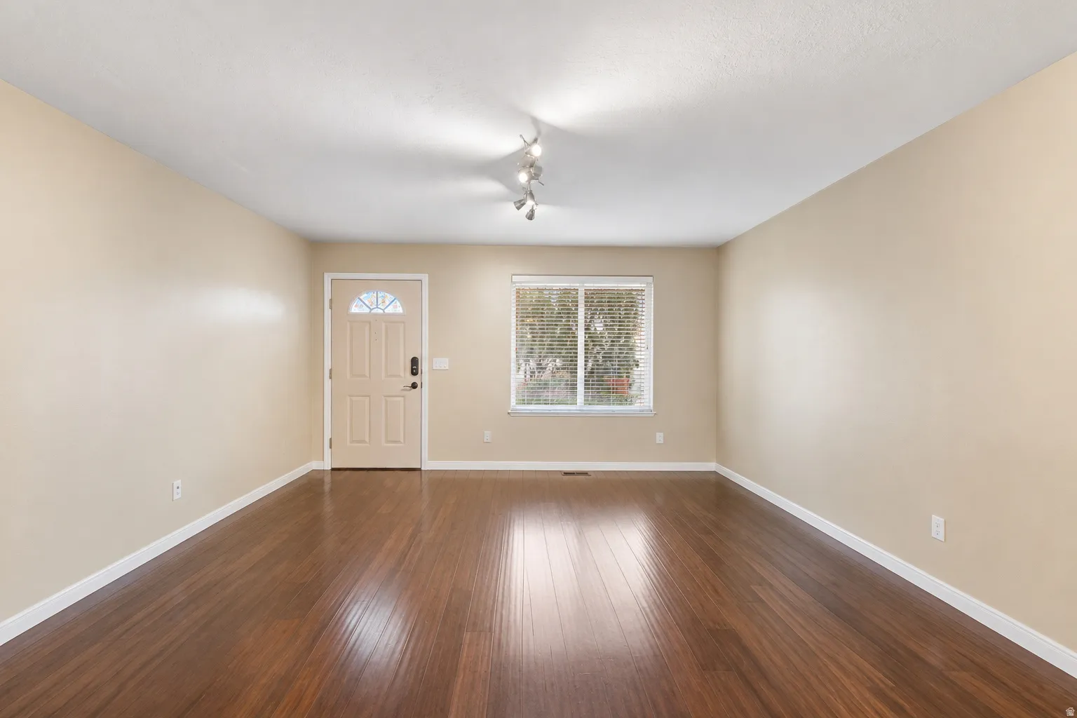 Warm-toned walls complement the rich wood-finish flooring