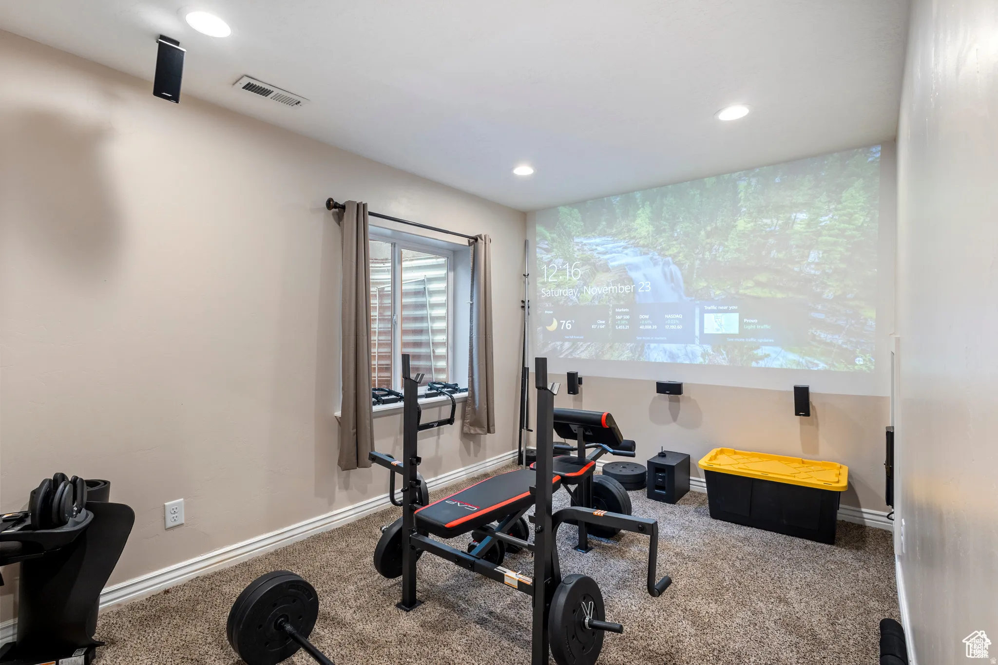 Dedicated room featuring a large projection screen, recessed lighting, and wall-mounted speakers
