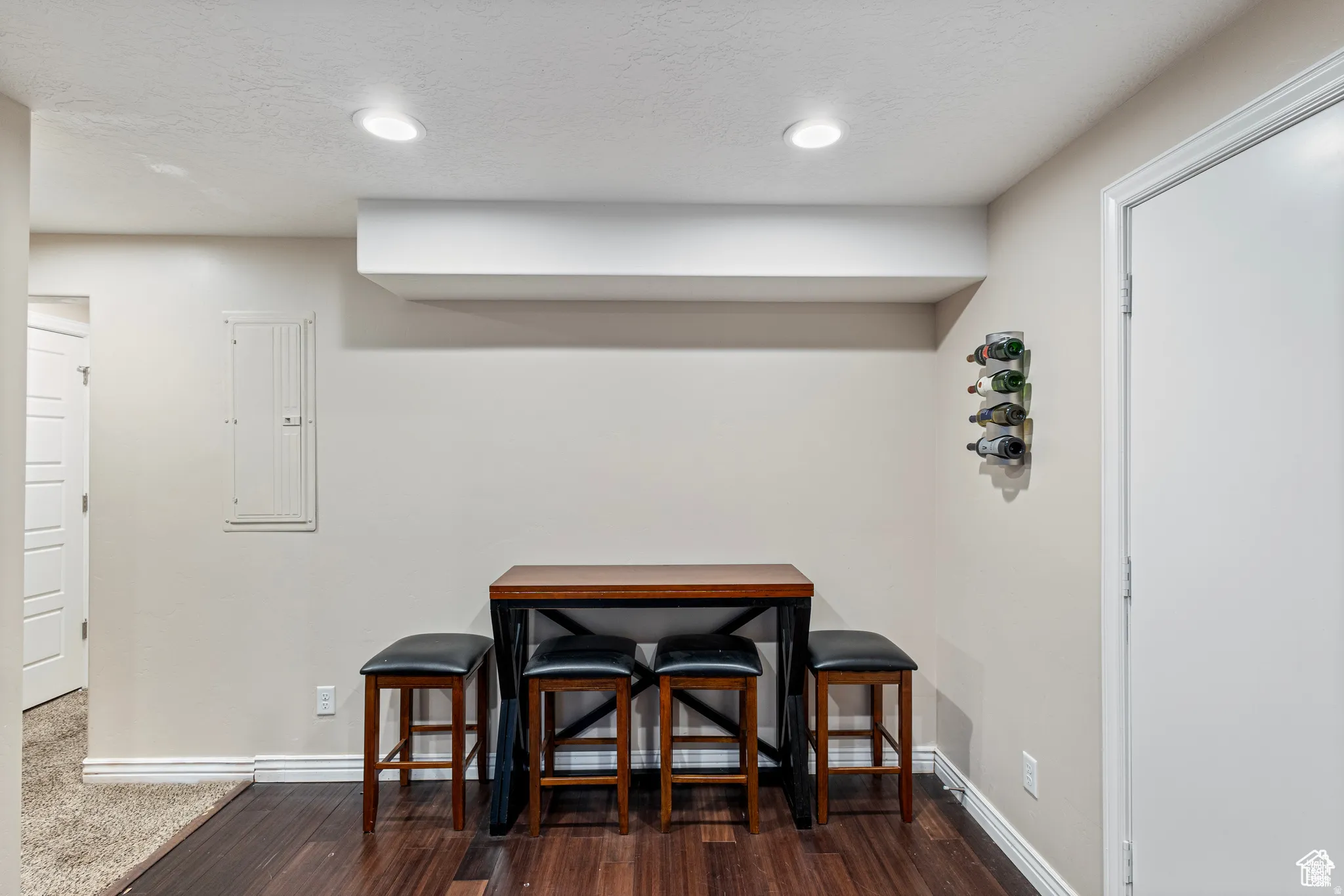 Recessed lighting illuminates the space featuring wood-finish flooring, white baseboards, and a white ceiling