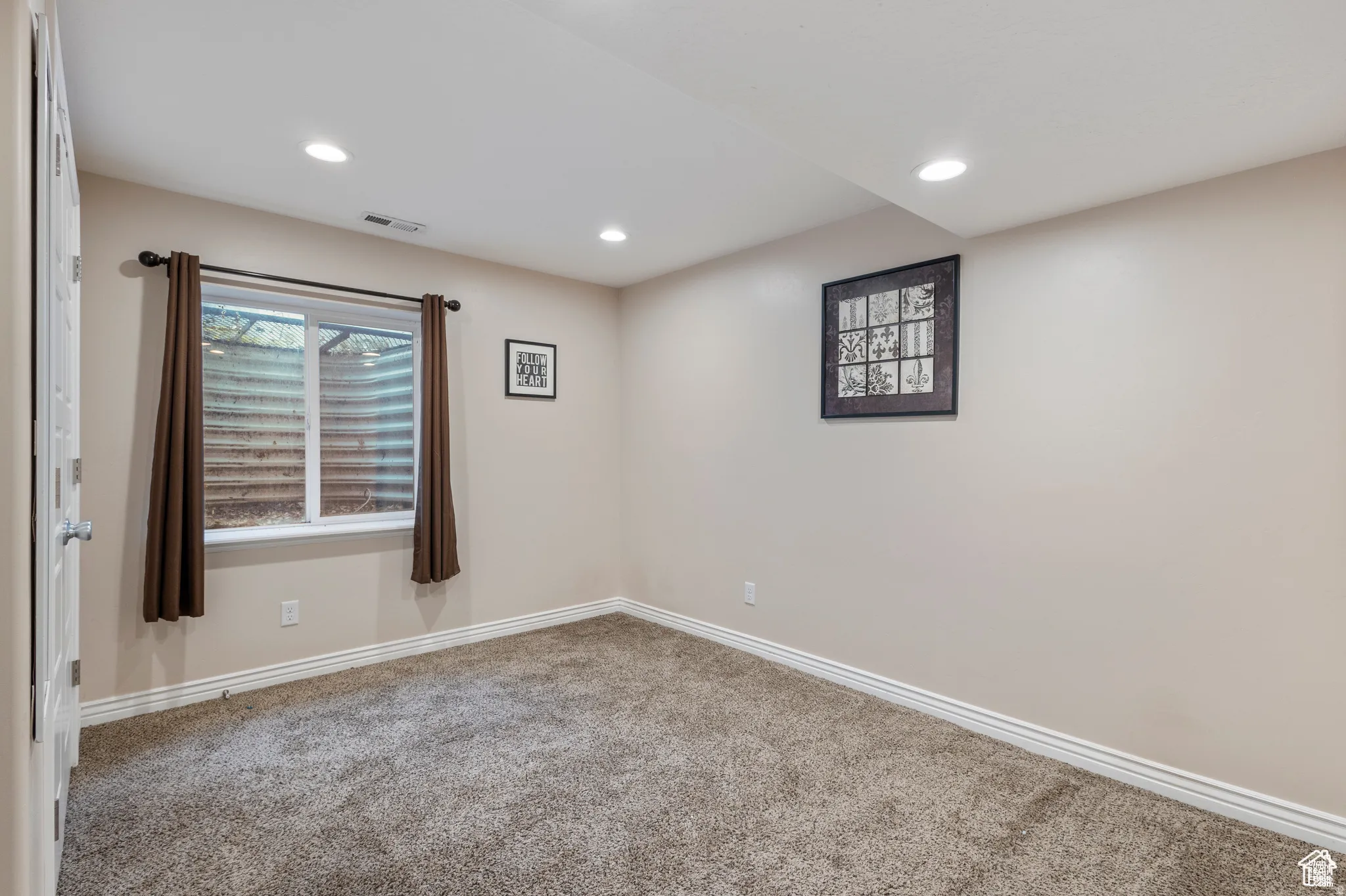 Carpeted room featuring a window with a window well, recessed lighting, and neutral wall paint